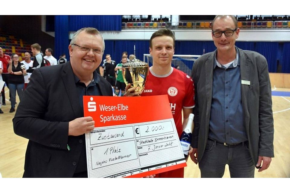 Der FC Oberneuland gewann das 21 Neujahrsturnier in der Bremerhavener Stadthalle und bekam von Stadtrat Torsten Neuhoff und Stadthallenmanager Bernd Sager den Sieger-Check in Höhe von 2000 Euro überreicht. F: Harneit