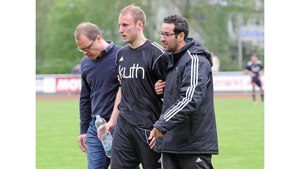 Mondorfs Jan Klinger (M.) verletzt sich kurz vor der Pause und wird von Martin Krämer (l.) und Co-Trainer Mustafa Bouzardaoui gestützt.