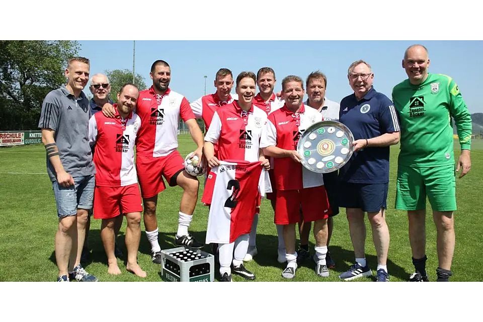 Der VfL Biedenkopf hat die Ü35-Kreismeisterschaft geholt, Kreisfußballwart Diether Achenbach (2. v. re.) überreicht den Wanderpokal in Form einer Schale. Nach dem Titel Samstag in Dautphe wird das VfL-Vereinslogo auf der Trophäe verewigt. © Jens Schmidt