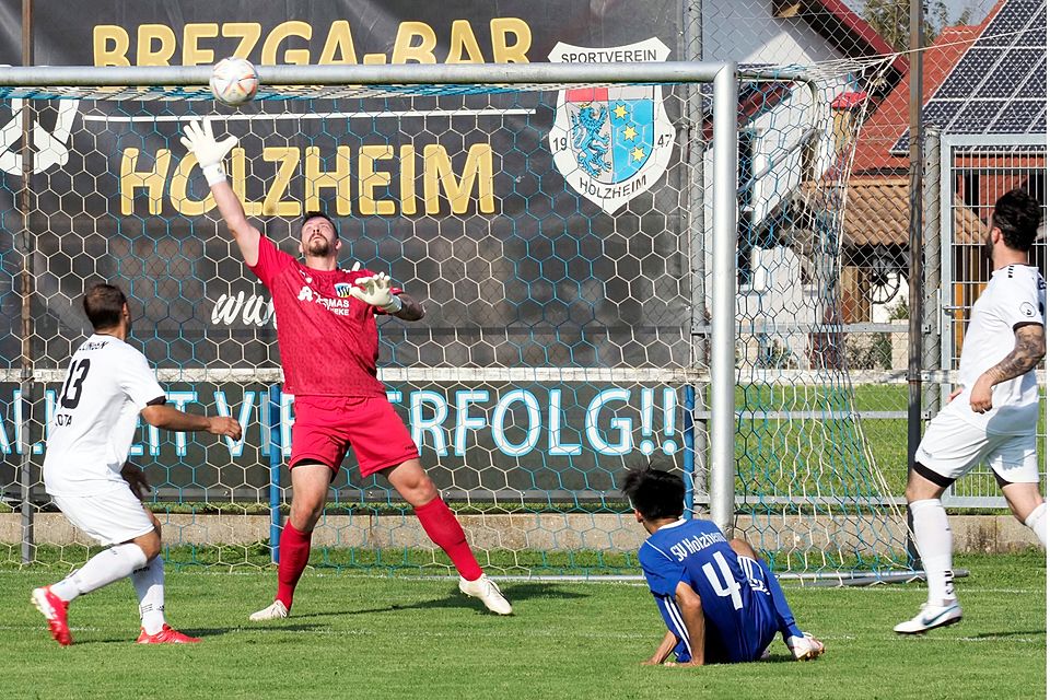 Holzheims Mohammad Mohammadi (am Boden) vergibt diese Großchance im Derby gegen Dillingen. SSV-Torwart Körber lenkt den Ball über die Latte. Konstantin Sakowrjaschin (weißes Trikot) schaut zu. 