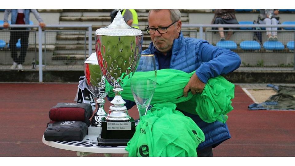 Was es diesmal wohl über die Haupttrophäe hinaus zu gewinnen geben wird? Kreisfußballwart und Pokalspielleiter Roland Paul beim Aufbau für eine der vergangenen Siegerehrungen. Foto: Sven Jessen © Sven Jessen