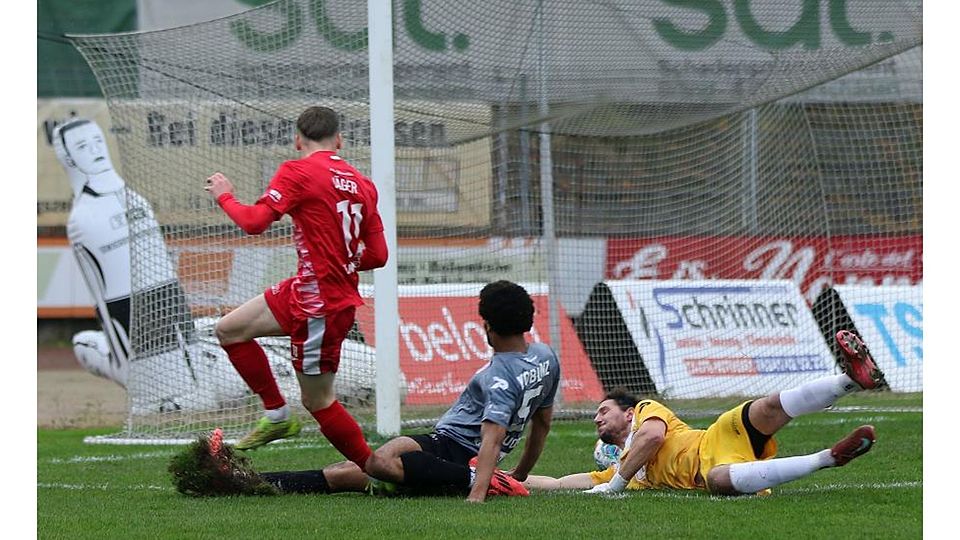 Frühe Führung: Wormatia-Angreifer Nico Jäger (rotes Trikot) schiebt den Ball an Koblenz-Torwart Marcel Behr vorbei ins Tor. Auch Abwehrspieler Daniel Brice Ndouop hat eine Chance, den Treffer zu verhindern.	Foto: Christine Dirigo/pakalski-press