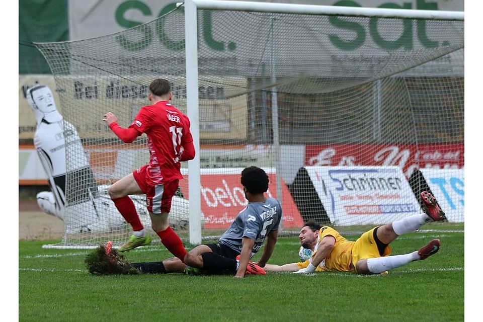 Frühe Führung: Wormatia-Angreifer Nico Jäger (rotes Trikot) schiebt den Ball an Koblenz-Torwart Marcel Behr vorbei ins Tor. Auch Abwehrspieler Daniel Brice Ndouop hat eine Chance, den Treffer zu verhindern.	Foto: Christine Dirigo/pakalski-press