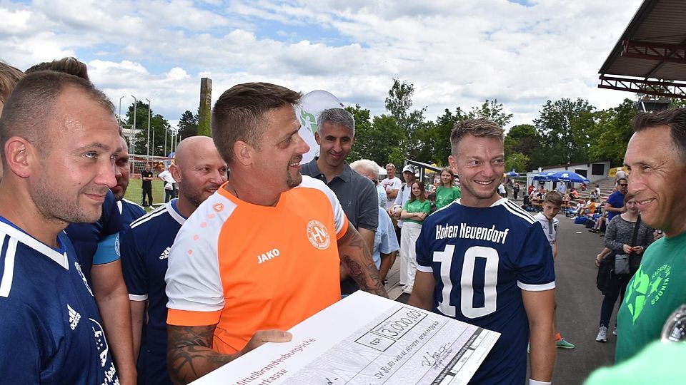 Die Berliner Spieler von Blau-Weiß Hohen Neuendorf brachten für „Kicken-für-Kinder“ Organisator Jürgen Fritz (rechts) einen Scheck mit.