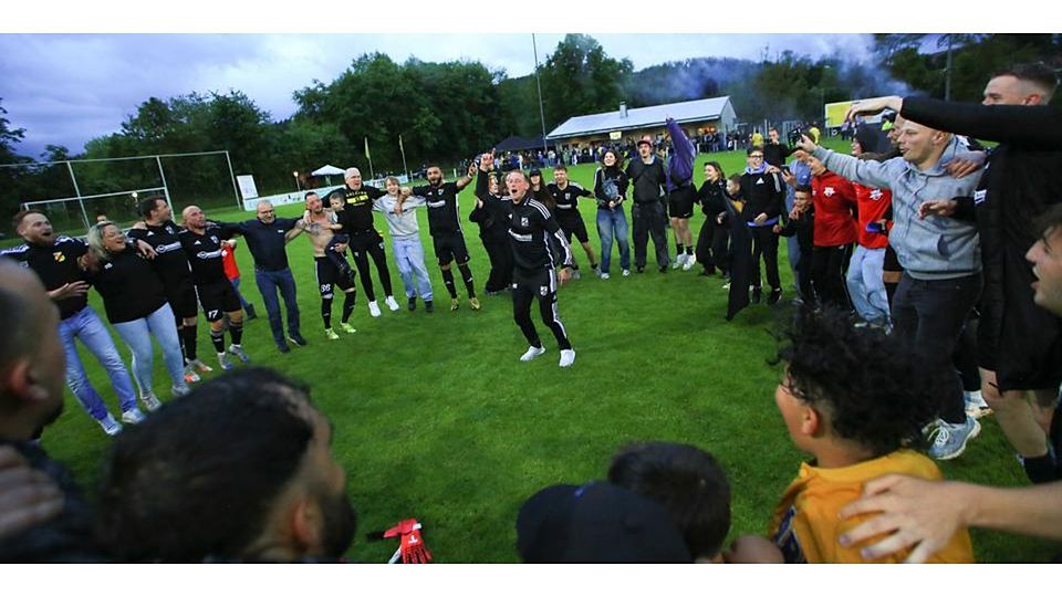 Erfolgscoach Jörg Muth stimmt im Kreis von Kickern und Fans die Calderner Fußballfamilie lautstark auf die Meistersause ein. © Jens Schmidt