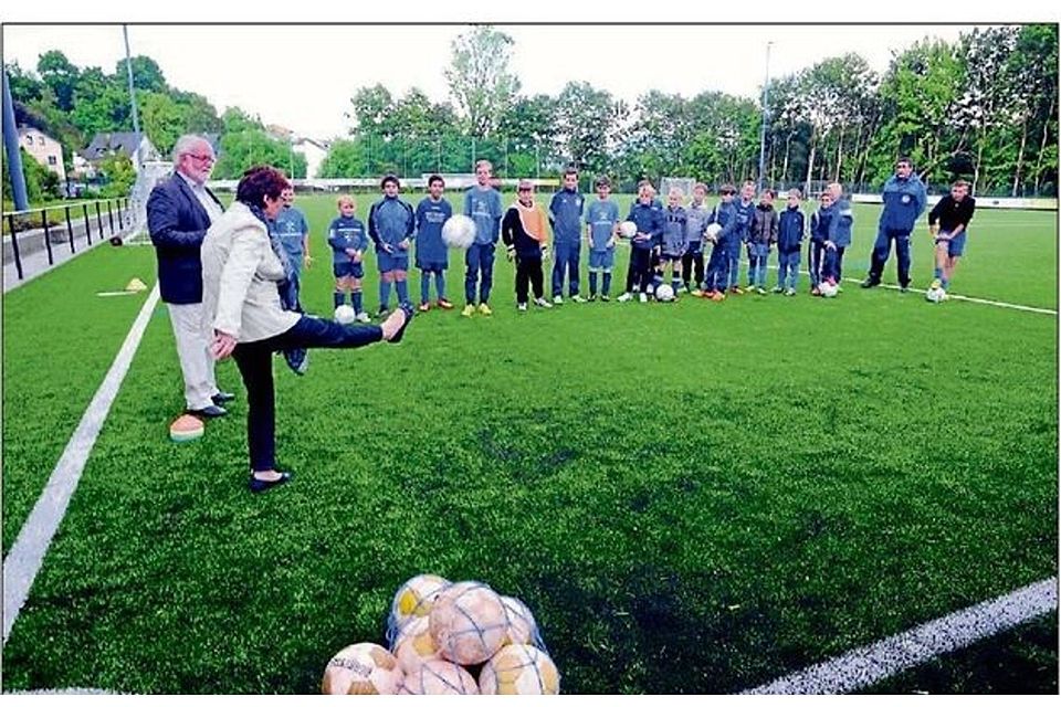 Wachtbergs Bürgermeisterin Renate Offergeld schoss auf dem neuen Kunstrasenplatz den ersten Ball im Beisein der Fußballjugend und des Vorsitzenden des SV Niederbachem, Hartwig Stock, ab. FOTO: SCHMELZEISEN