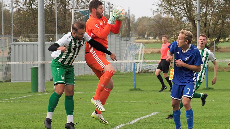 Holzheims Keeper Florian Hofmeister pflückt sich hier den Ball vor Ichenhausens Angreifer Aygün Aslanboga (rechts David Peter). 