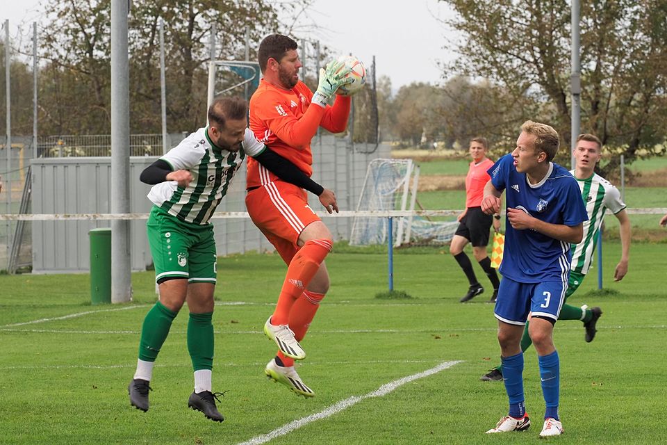 Holzheims Keeper Florian Hofmeister pflückt sich hier den Ball vor Ichenhausens Angreifer Aygün Aslanboga (rechts David Peter). 