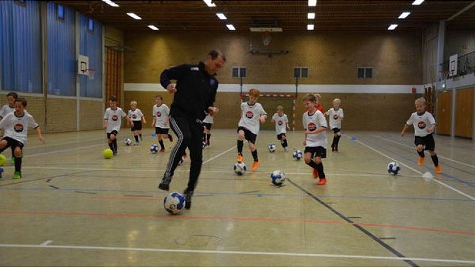 Ex-Profi Joe Enochs zeigt den Nachwuchskickern, wie man aus vollem Lauf den Ball stoppt. Foto: Reinhard Fanslau