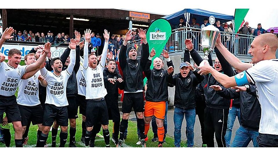 Nach 0:2-Rückstand hat der SSC Burg in der Nachspielzeit mit 3:2 gewonnen. Kapitän Maximilian Metz präsentiert seiner Mannschaft die Trophäe. Foto: Lorenz Pietzsch 