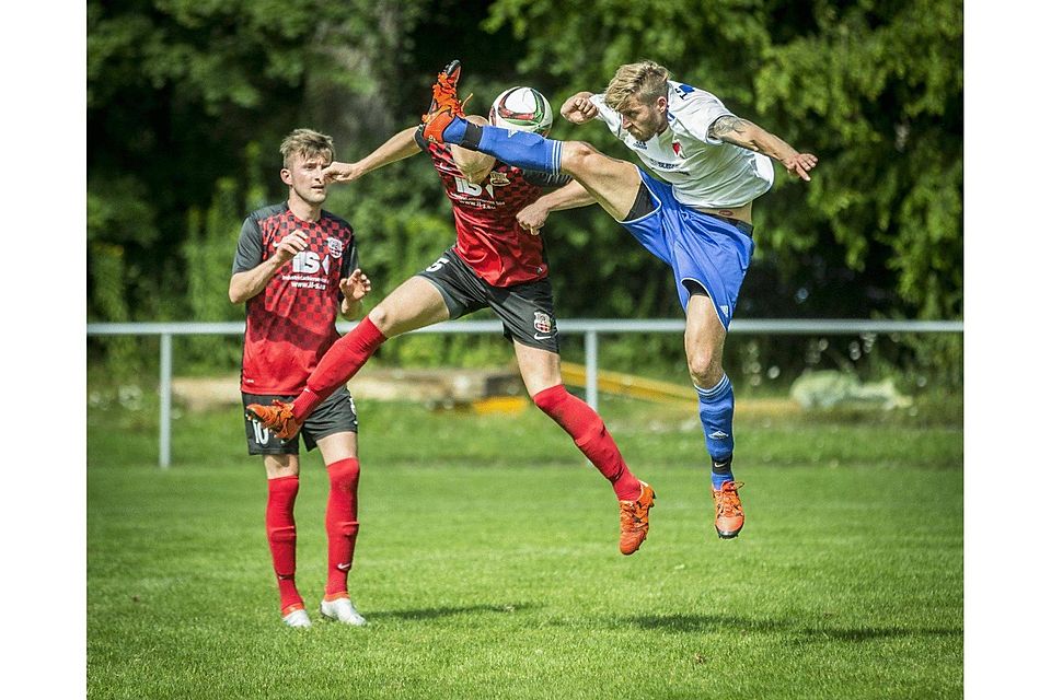 Hoch das Bein: Der Holzheimer Patrick Ostheimer (rechts) gegen Gjentijan Haxhijaj  (Mitte) vom FC Blaubeuren. Foto: Matthias Kessler