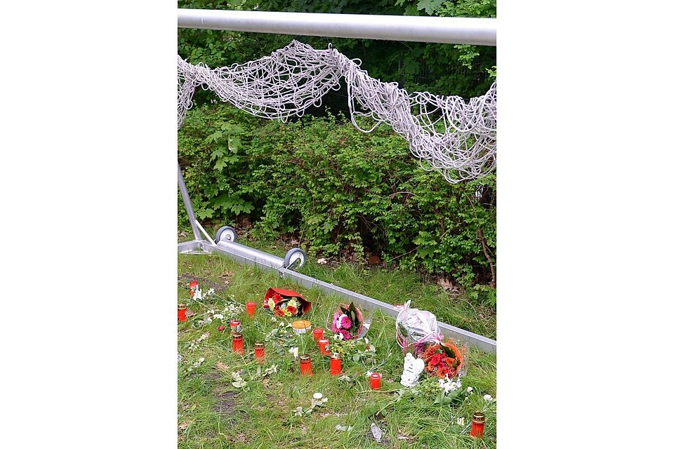 An der Unglücksstelle auf einem Fußballplatz in Hamburg wurden Kerzen und Blumen niedergelegt.  Foto: dpa