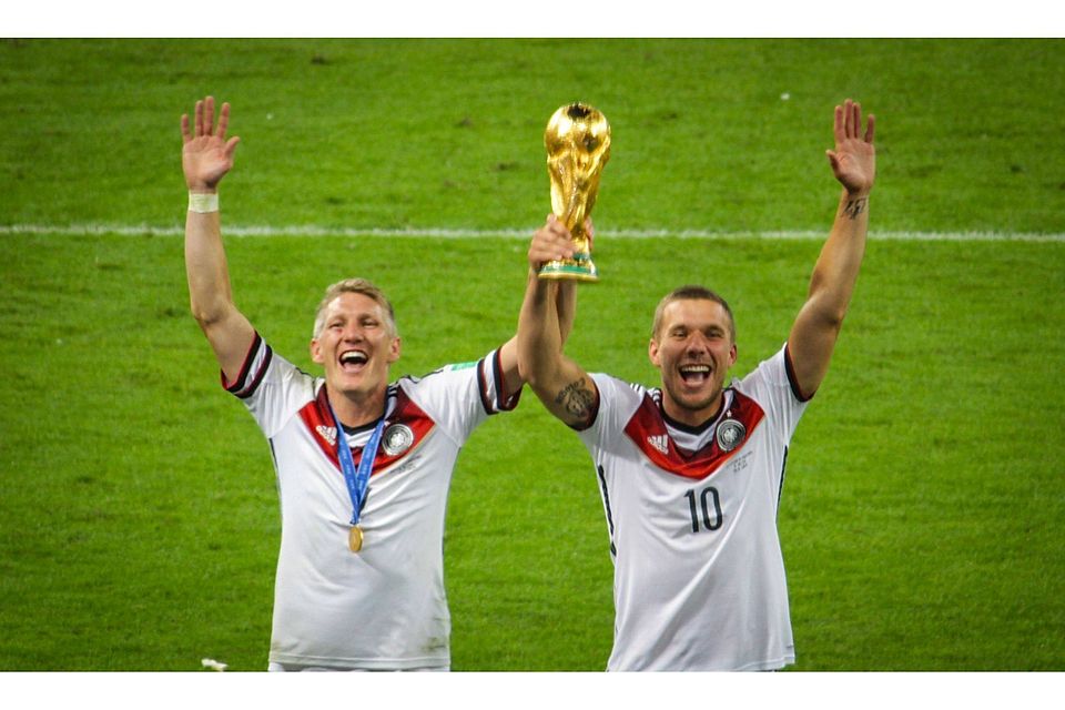 Bastian Schweinsteiger und Lukas Podolski jubeln mit dem WM-Pokal. Foto: Sven Bock