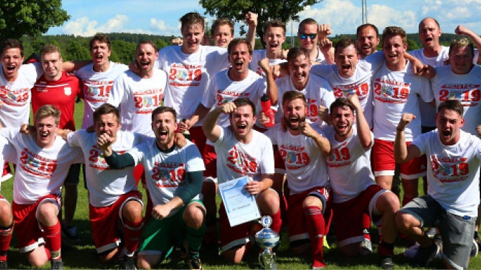 Die Meistershirts waren in Hohenfurch schon vorbereitet und konnten direkt nach dem Heimsieg gegen Wessobrunn angezogen werden. Spielleiter Heinz Eckl (rechts) überreichte noch auf dem Feld den Meisterpokal. Foto: Herold