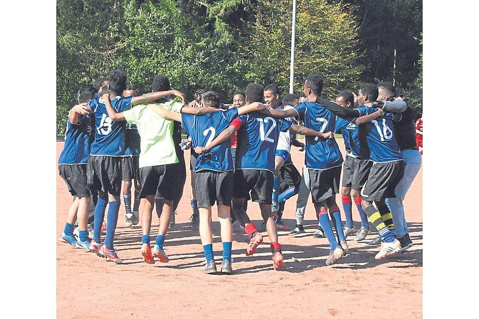 Erst brav aufgestellt, später ausgelassen gejubelt: Der FC Rambach United (blaue Trikots) bestreitet sein erstes Freundschaftsspiel gegen die SG Rambach/Kloppenheim II. 	 Foto: SG Rambach/Kloppenheim