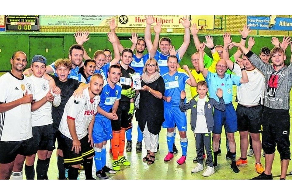Siegerehrung: Pokalstifterin Heidi Berks (Mitte) überreicht dem Spielführer Patrick Klein der BSG Würselen den Pokal. Foto: Wolfgang Sevenich