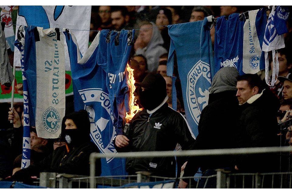 Vermummte Eintracht-Fans verbrennen im Bundesliga-Hinspiel Darmstadt-Fahnen. Foto: Hübner/Ulrich