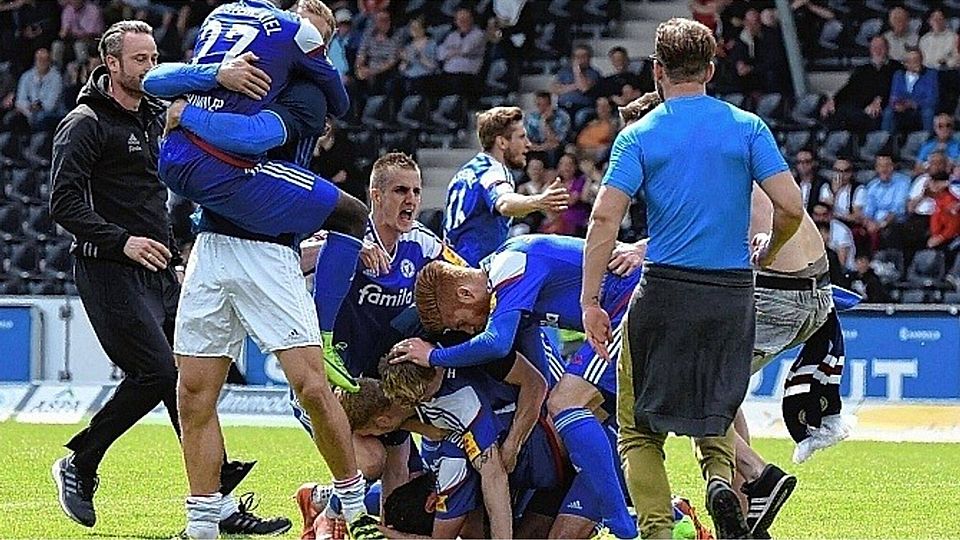 Jubeltraube: Viele Spieler, Physiotherapeut Tim Höper und die ersten Fans (rechts) fallen schon kurz nach dem Abpfiff regelrecht übereinander her. Foto: getty