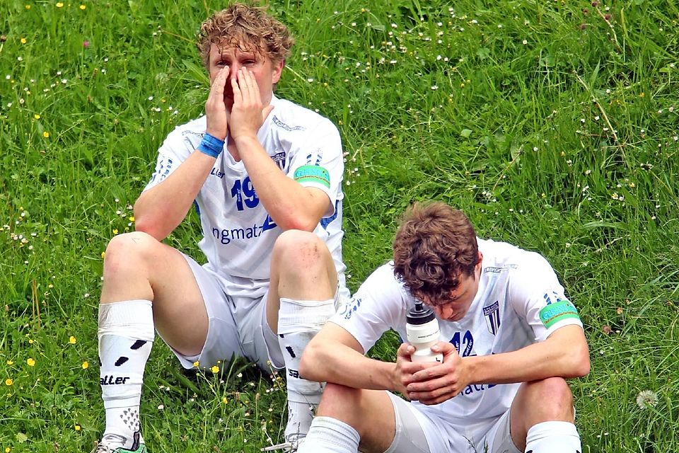 Die FC-Spieler Christoph Schmitt und Florian Adlwaerth sitzen mit Tränen in den Augen am Spielfeldrand.