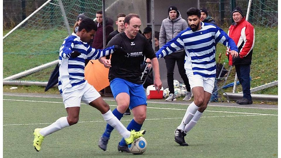 René Stockbauer (Mitte, FSG Weilnau/Weilrod/Steinfisachbach) ist eingeklemmt zwischen zwischen Haben Gazae Embaye (links) und Ali Shahewer von der SpVgg 05/99 Bomber Bad Homburg.	Foto: jf