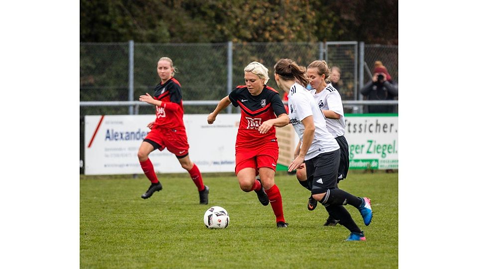 Energisch treibt Nadine Enoch vom SV Jungingen (Mitte, rotes Trikot) den Ball nach vorne.  