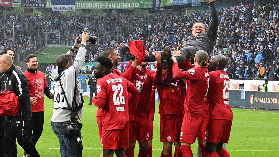 Uwe Koschinat feiert den Pokalsieg mit seinen Spielern und den Fans.