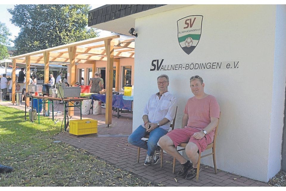 Gerd Bigge (links), Vorsitzender des SV Allner-Bödingen, und sein Stellvertreter Jens Frandrup genießen den Schatten vor dem Clubheim. FOTO: JÜNGER