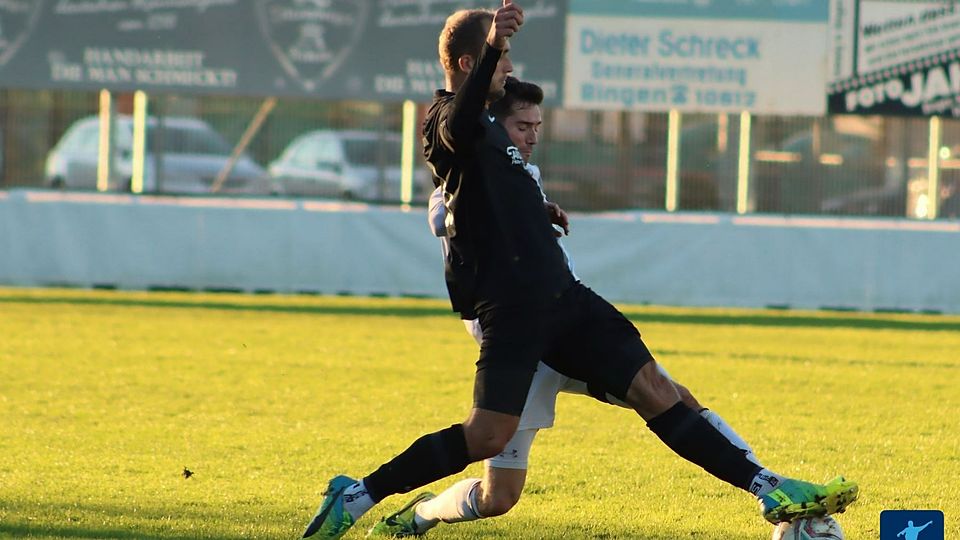 Alexander Rimoldi (hier schwarz, im Duell mit Hassia Bingen) sorgte in letzter Minute für die Entscheidung im Spitzenspiel der Verbandsliga.