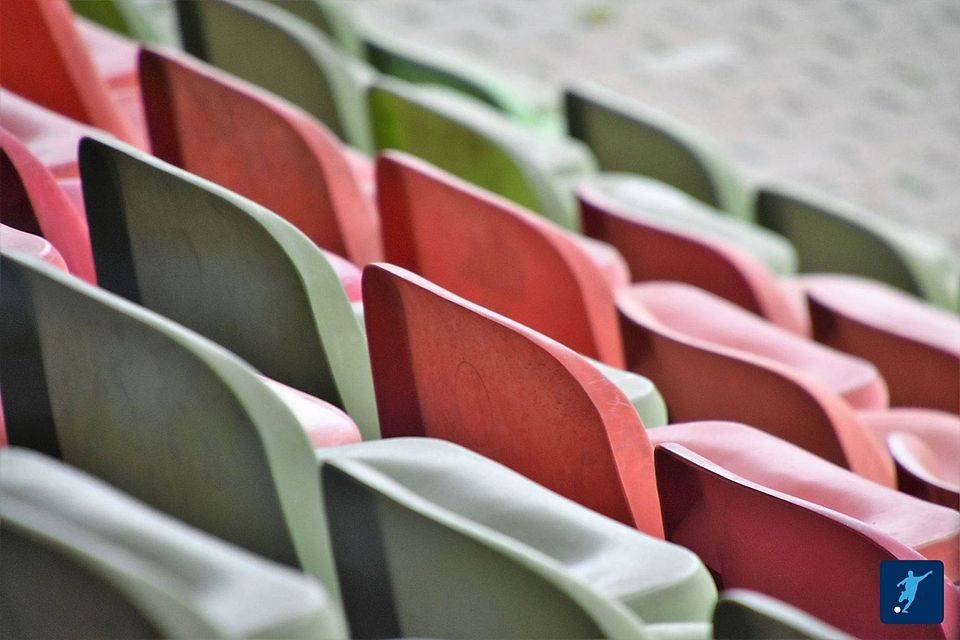 Sitzschalen auf einer Tribüne in einem Stadion.
