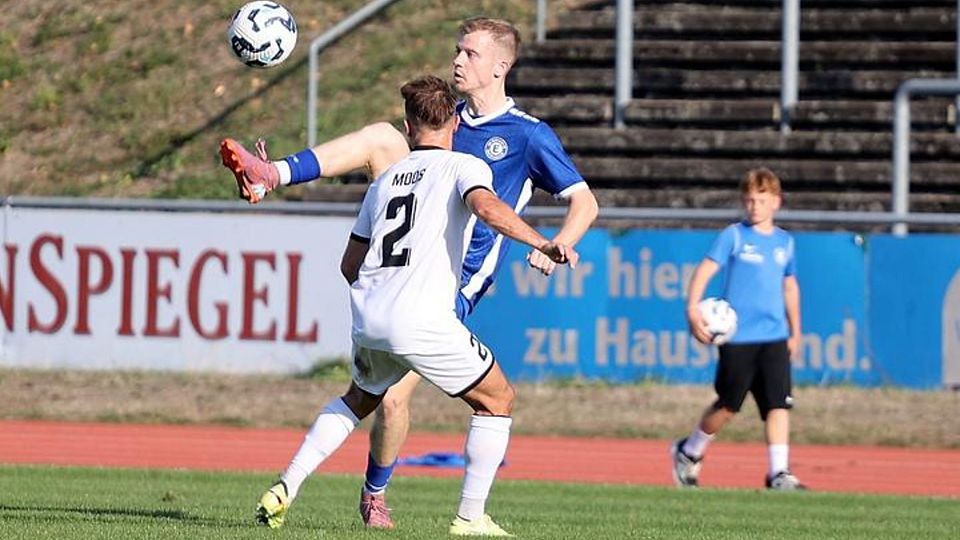 Ball hochhalten: Eintrachtler Deniz Cinat (blaues Trikot) nimmt das Spielgerät artistisch mit. Szene aus dem Duell mit der Ludwigshafener Arminia um Malte Moos, die Samstag in Waldalgesheim gastiert.