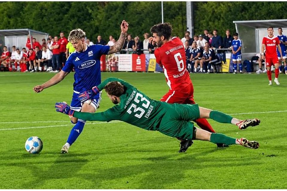 Schott-Torjäger Gianni Auletta (blaues Trikot) hat hier im Verbandspokal-Achtelfinale das 4:0 auf dem Fuß, aber Hüffelsheims Keeper Tobi Edinger macht sich lang und pariert. Sein Teamkollege Sascha Mockenhaupt muss nicht mehr eingreifen. Foto: Mario Luge Schott-Torjäger Gianni Auletta (blaues Trikot) hat hier im Verbandspokal-Achtelfinale das 4:0 auf dem Fuß, aber Hüffelsheims Keeper Tobi Edinger macht sich lang und pariert. Sein Teamkollege Sascha Mockenhaupt muss nicht mehr eingreifen. Foto: Mario Luge