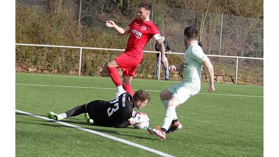 Endstation Maximilian Schäfer: Der Pfeddersheimer Marcell Oehler (rotes Trikot) kommt in dieser Szene nicht am Torwart des VfR Grünstadt vorbei, der von Mitspieler Nico Müller (rechts) unterstützt wird.	Foto: Axel Schmitz/pakalski-press