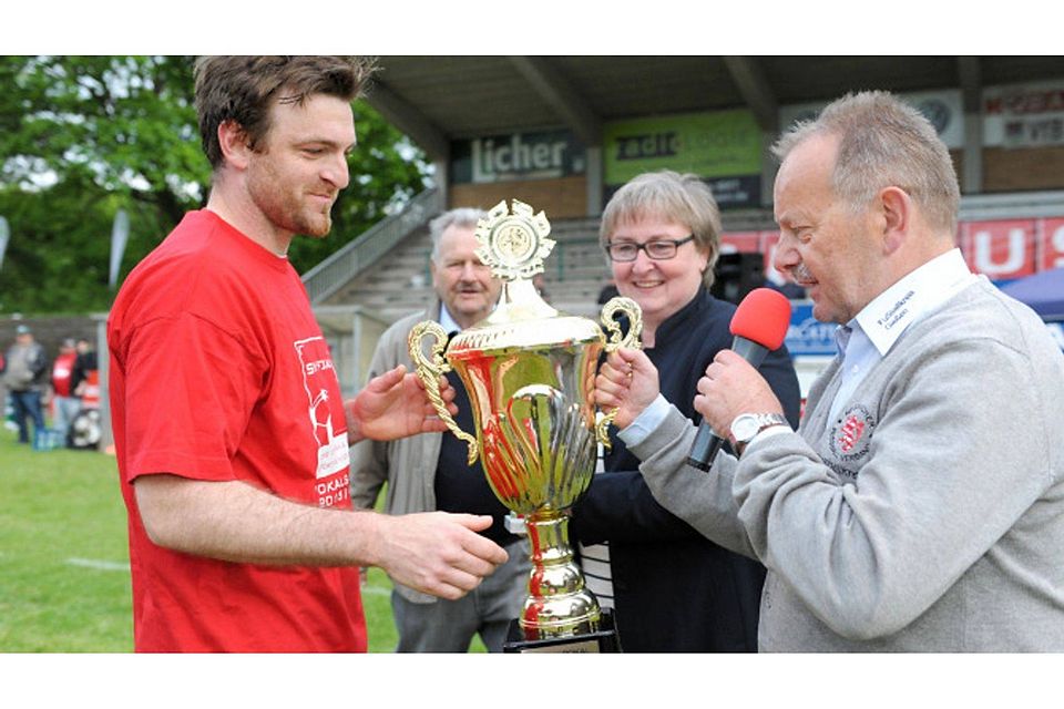 Auch schon wieder drei Jahre her: Aber den Pokal gibt es noch. Henry Mohr überreicht 2016 den Pott an Watzenborns Spielführer Patrick Neubert. 	Archivfoto: Schepp