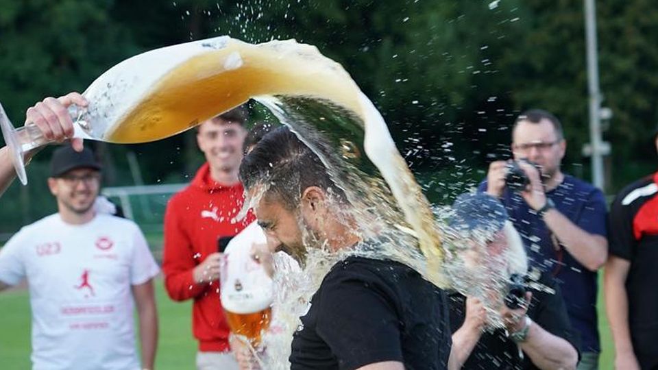 Ercan Dursun, der nach dem Verbandsliga-Aufstieg mit RWW II eine Bierdusche abbekommt.