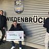 Hilfsbereitschaft: Daniel Brinkmann, Marcel Hölscher und Alexander Brentrup (v.l.) vom SC Wiedenbrück mit dem symbolischen Spendenscheck.