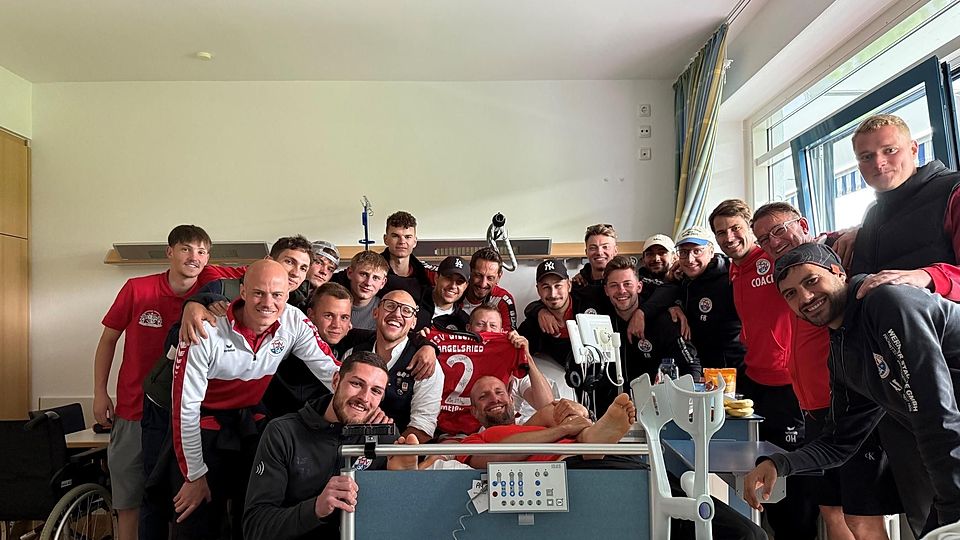 Krankenbesuch: Nach der erfolgreichen Relegation machten die Gilchinger um ihren scheidenden Trainer Robert Brand (3.v.r.) noch Halt im Starnberger Krankenhaus, um den im Hinspiel schwer verletzten Christoph Meißner (M., versteckt hinter Trikot) zu besuchen.