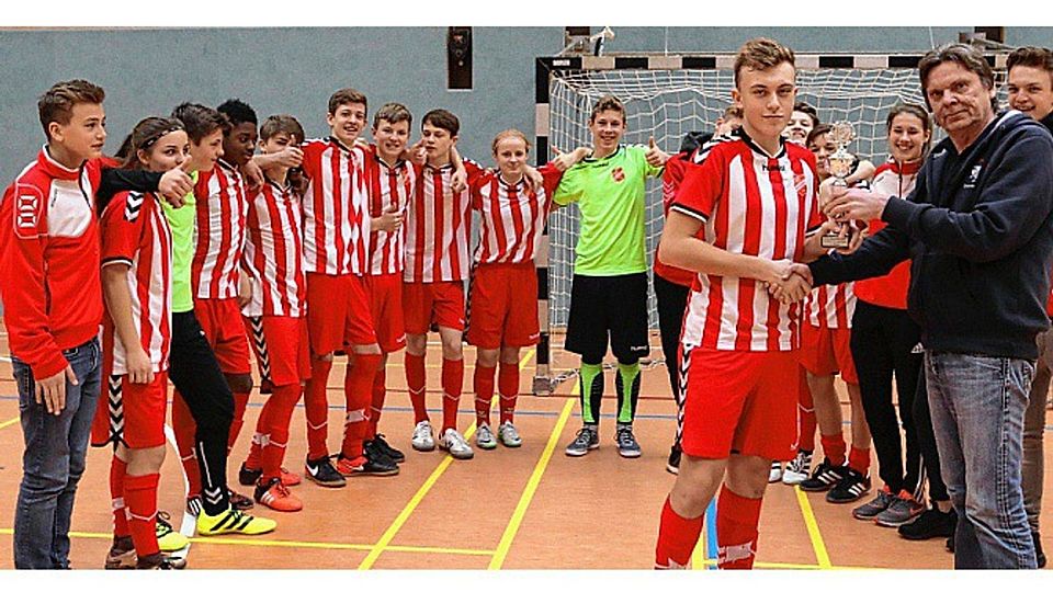 Staffelleiter Waldemar Wasken überreichte der C-Jugend des SV Eichede den Pokal für den Sieg bei der Hallenkreismeisterschaft.