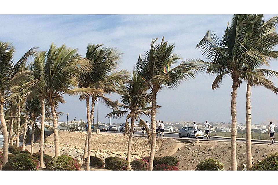 Nur wenige Wolken und Palmen beherrschen das Bild in Oman, während in Deutschland frostiger Winter ist.