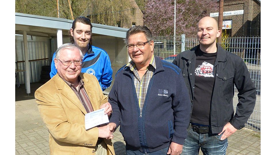 Rolf Lüpertz vom FVN (links im Vordergrund) übergibt Ortwin Eckert vom SV Dohr (vorne rechts) den Scheck. Foto: Sascha Köppen