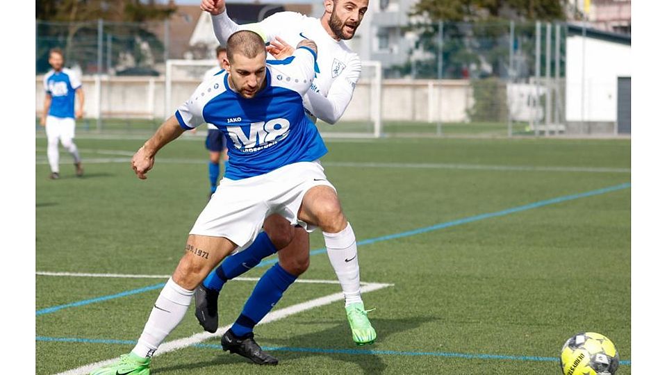 Jannik Heßler von der SG Langstadt/Babenhausen (blaues Trikot) im Zweikampf mit Münsters Kapitän Arian Sahitolli. Torjäger Heßler fehlt am Sonntag verletzt.	Foto: Guido Schiek