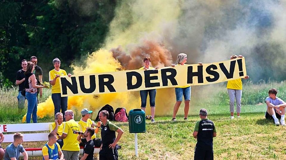 Der Zusammenhalt beim Bezirksligisten SV Hölzlebruck ist enorm. Im Vordergrund freut sich Trainer Tobias Urban, die Frauen mit dem Banner verschwinden wenig später in einer riesigen Rauchwolke. 