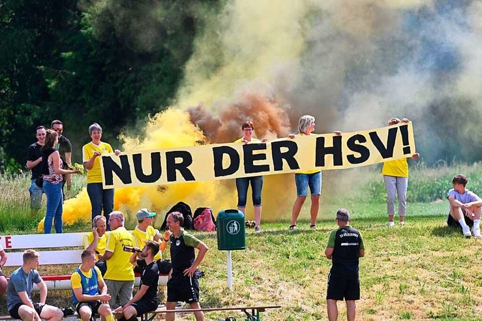Der Zusammenhalt beim Bezirksligisten SV Hölzlebruck ist enorm. Im Vordergrund freut sich Trainer Tobias Urban, die Frauen mit dem Banner verschwinden wenig später in einer riesigen Rauchwolke. 