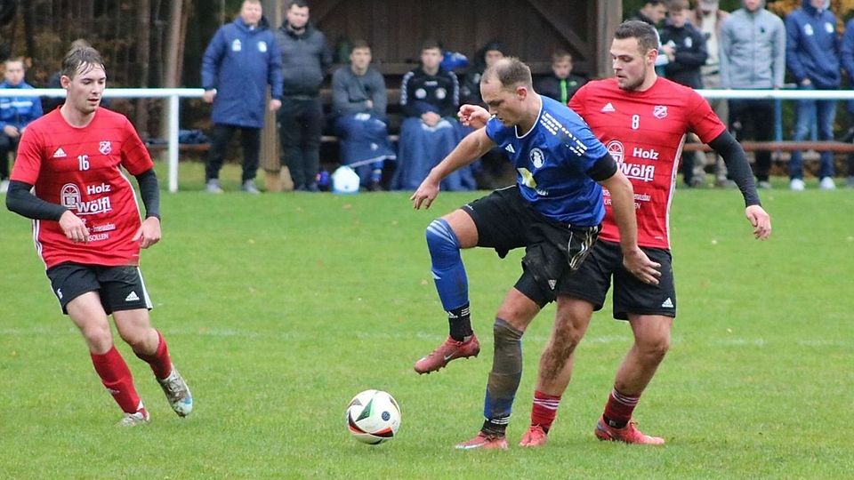 Schwerstarbeit musste die DJK Ursensollen (in Rot-Schwarz) verrichten, um durch einen späten Treffer den vollen Ertrag vom Edelsfelder Hahnenkamm (der FC in Blau-Schwarz) mitnehmen zu können.