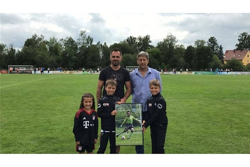 Stephan Pröls (links) – hier mit seinen beiden Kindern Nina und Moritz – bekam vom FV-Vorstand Robert Liermann auch ein Foto überreicht, das den langjährigen Keeper bei einem Spiel zeigt.  Foto: ama