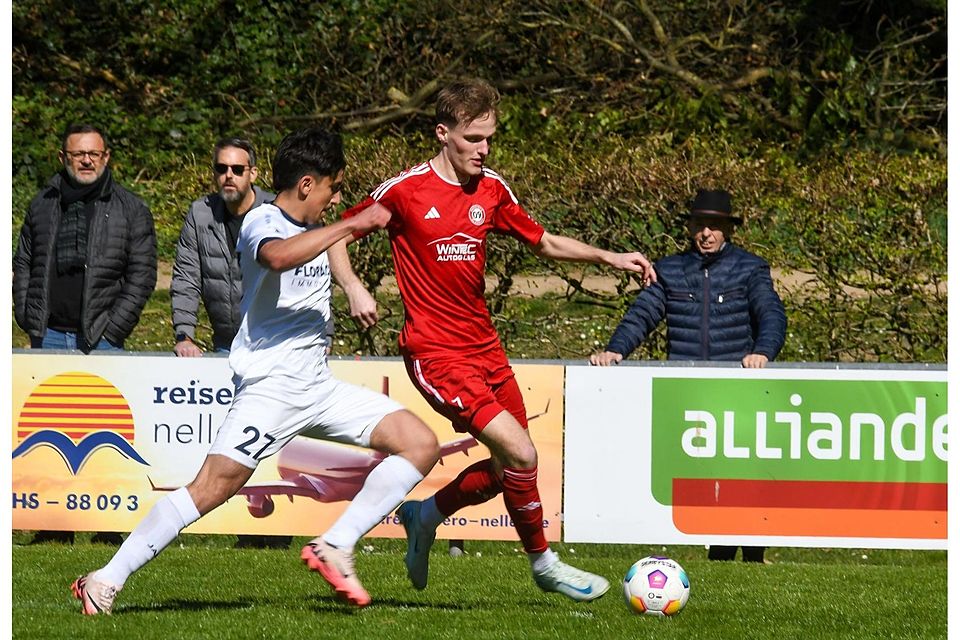 Finn Stromberg (rotes Trikot) von den Gästen kann den Ball noch vor dem heranstürmenden Max De Oliveira retten.