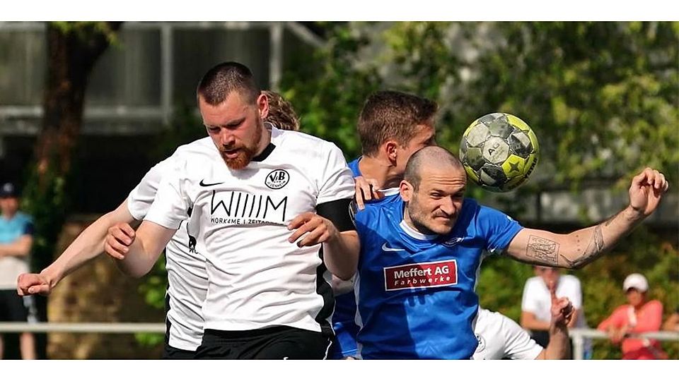 Augen zu und durch: Sebastian Baumann (blaues Trikot) im Kopfballduell mit Bodenheims Calvin Faßnacht.	Foto: Haas