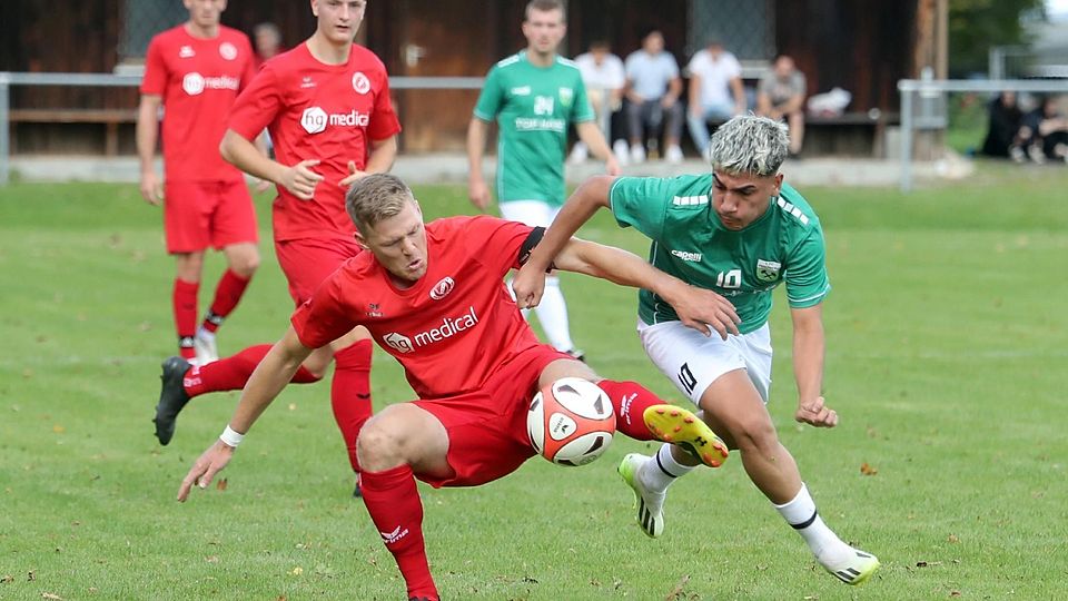 Viel Kampf war in der Vorrunde zu sehen: Im Hinspiel setzte sich der FC Penzberg (in Grün, hier der mittlerweile verletzte Ugurkan Verep) gegen den SV Raisting (in Rot, vorn mit Viktor Neveling) mit 1:0 durch.
