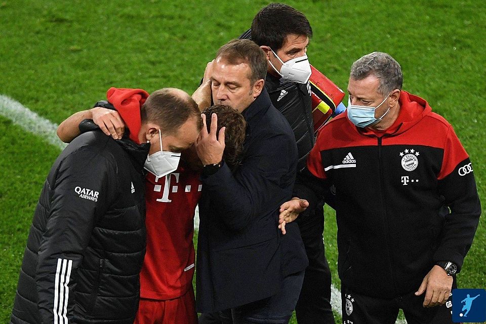 Bayern-Coach Hansi Flick (3.v.re.) tröstet Joshua Kimmich, der verletzt vom Platz geführt werden musste.