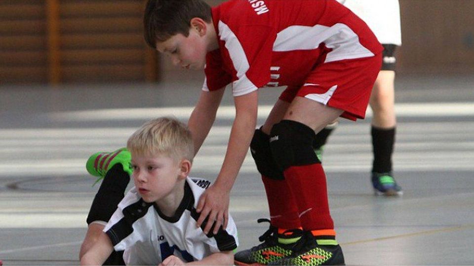 Charakteristisch: In dieser Szene machte es der F-Junior des MSV Neuruppin (in Rot) vor, was im Vordergrund stand beim 3. Eisernen Sparkassen-Cup. Es ging um ein faires Miteinander beim Sport. Jeder sollte Spaß haben. Hier half er seinem Rhinower Gegenspieler wieder auf die Beine. Foto: Matthias Haack