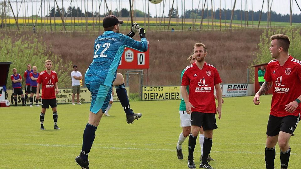 Haltungsnote Eins: Paunzhausens Schlussmann Julius Gassner faustet im Spiel gegen die FVgg Gammelsdorf einen hohen Ball gekonnt weg. Seine Mitspieler (rote Trikots) schauen ihm gespannt dabei zu.